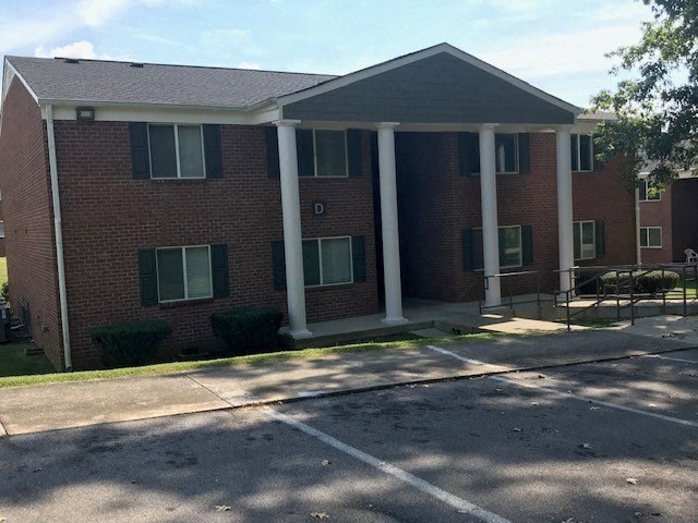 a brick building with white pillars in front of it