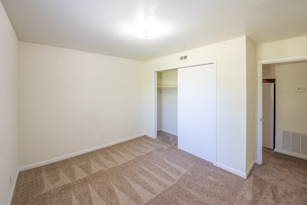 a bedroom with white walls and carpet