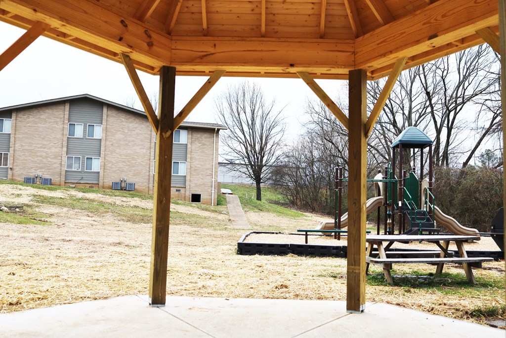 the playground is under a pavilion in the back yard of a house
