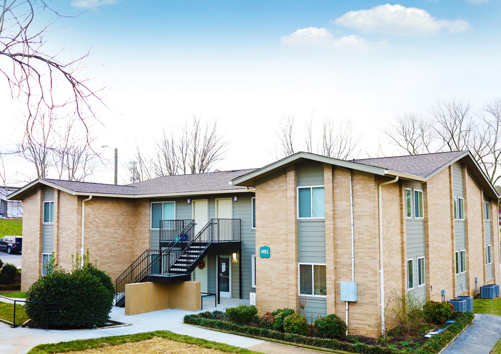 a brick apartment building with stairs and a sidewalk