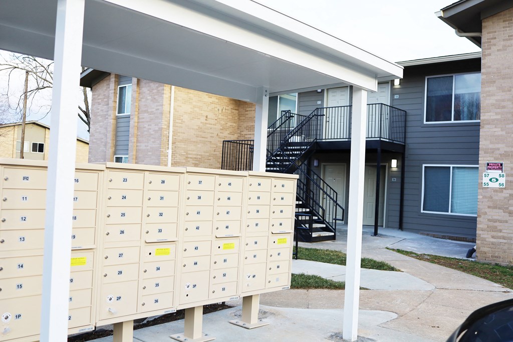 a group of mailboxes outside of a house with a staircase