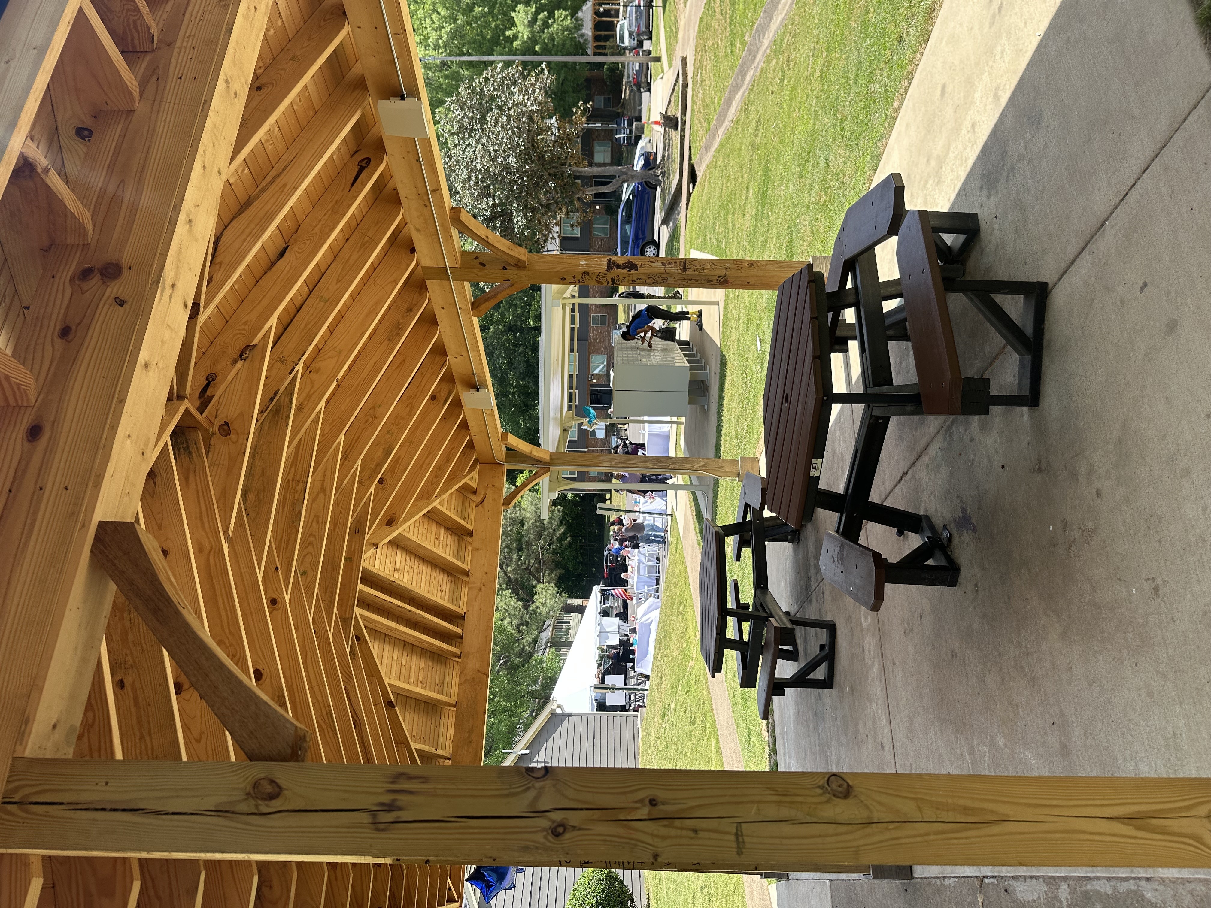 A wooden pavilion with picnic tables underneath