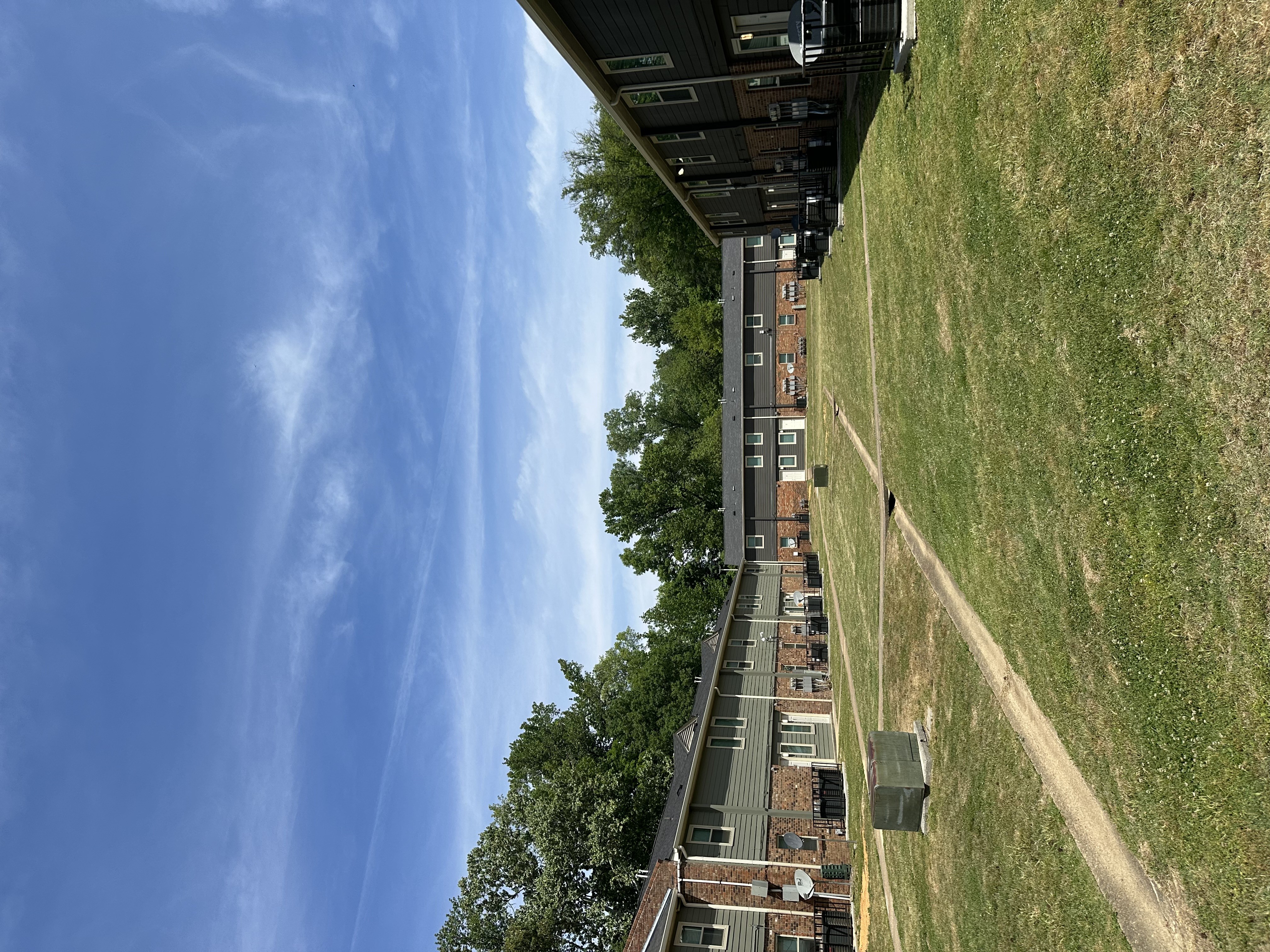 Apartment building with a green lawn in front of it.