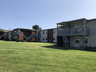 a row of apartment homes and freshly cut lawn pictured against a clear blue sky