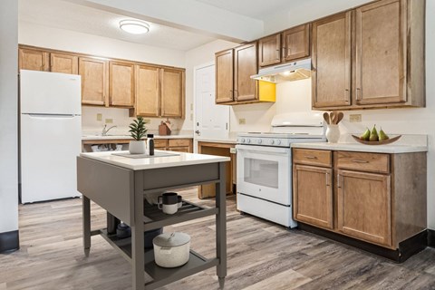 A kitchen with wooden cabinets and a white fridge.