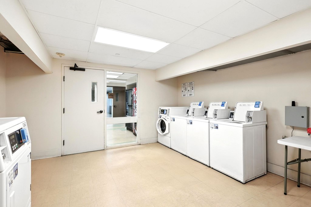 A laundry room with washing machines and a table.