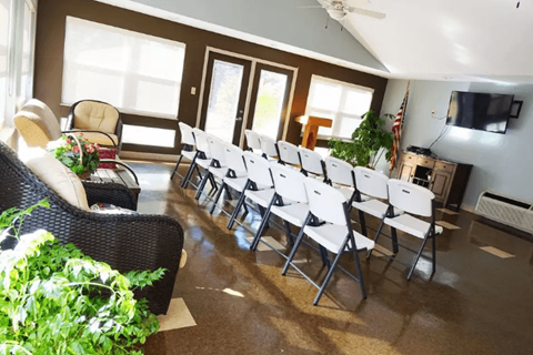 a room with white chairs and a tv in the corner