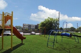 A playground with a yellow slide and a blue slide.