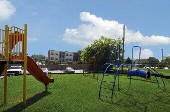 A playground with a yellow slide and a blue slide.