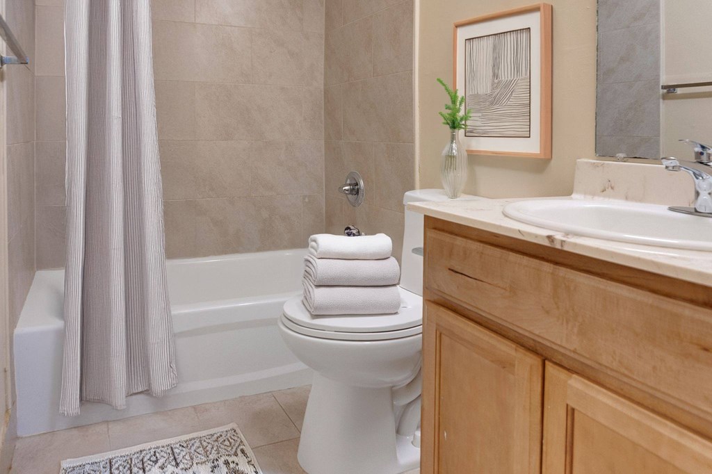A bathroom with a white toilet, a white sink, and a shower curtain.