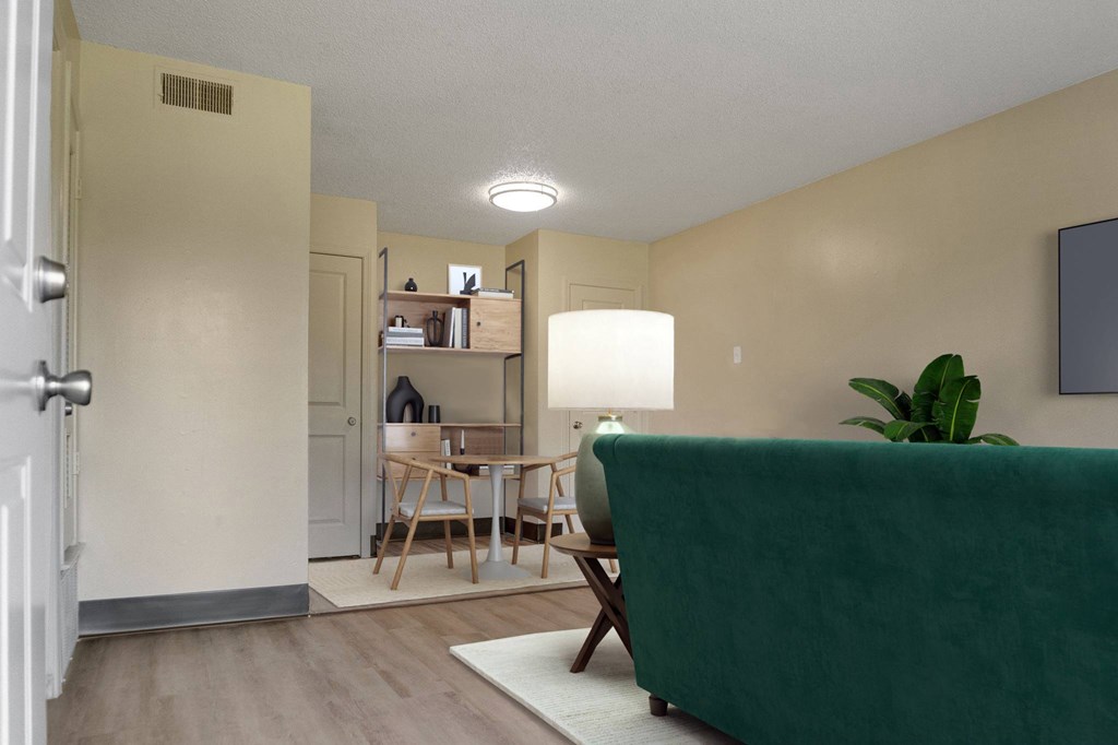 A living room with a green couch and a wooden table.