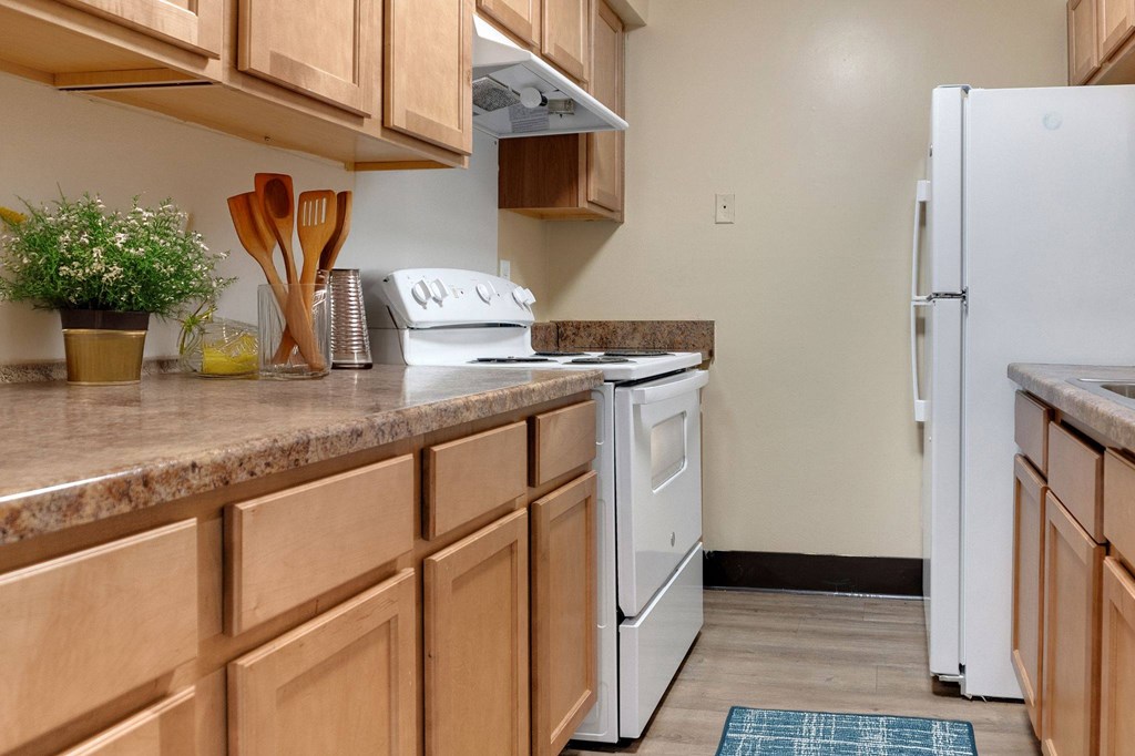 A kitchen with wooden cabinets and a white refrigerator.
