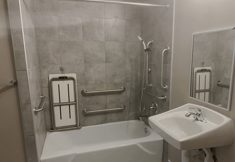A white bathtub sits next to a white sink in a bathroom.