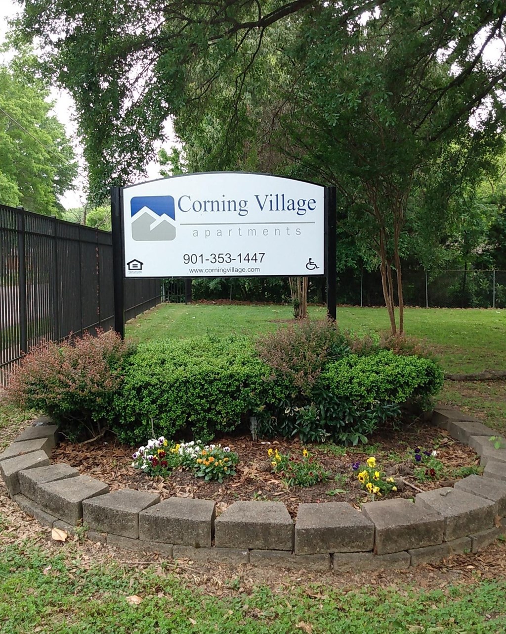 a sign forcoming village in front of a park