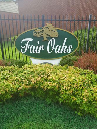 a sign for fair oaks in front of a fence