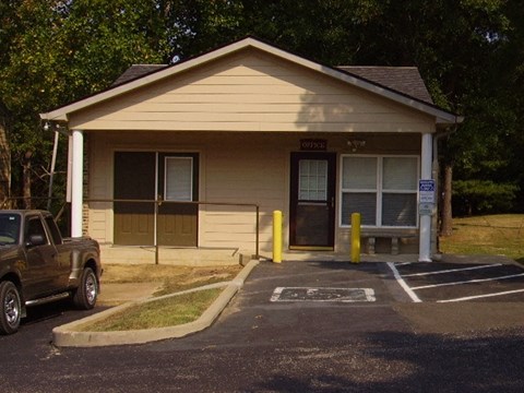 a small house with a truck parked in a parking lot