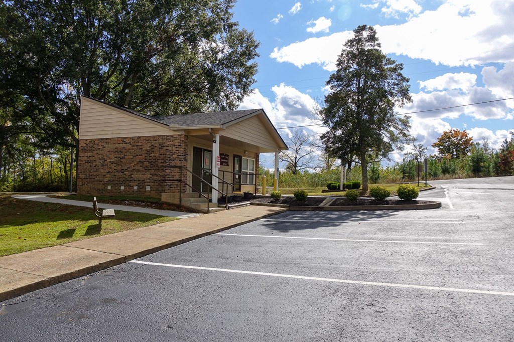 a small building with a parking lot in front of it