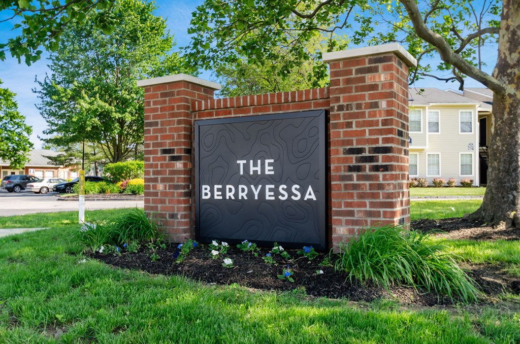 A sign that says "The Berryessa" is mounted on a brick wall.