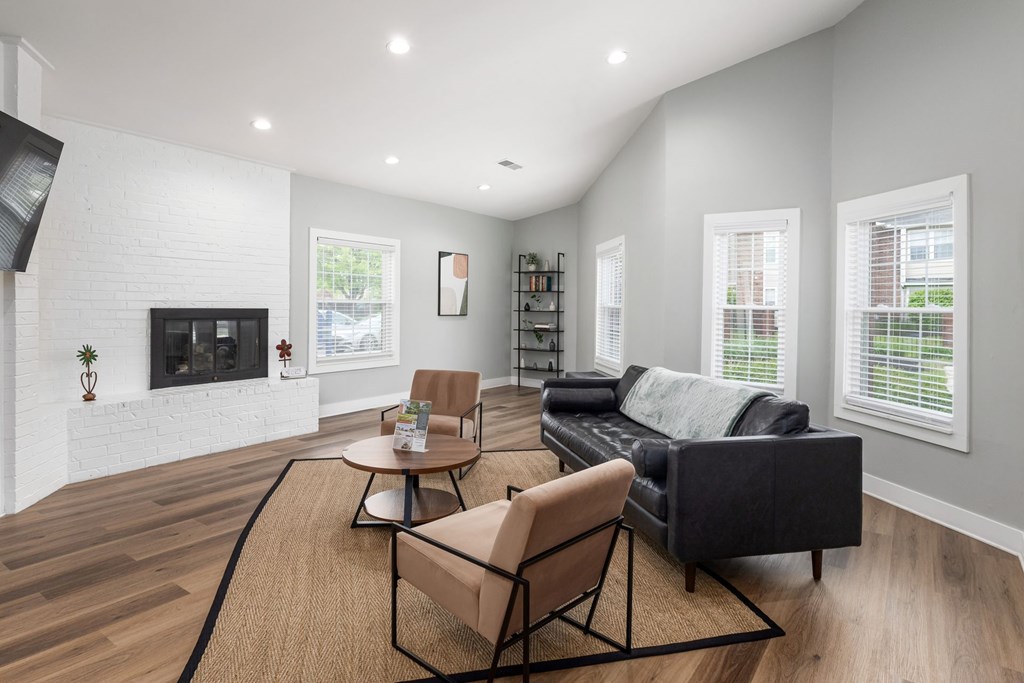 A living room with a black couch, a chair, and a coffee table.