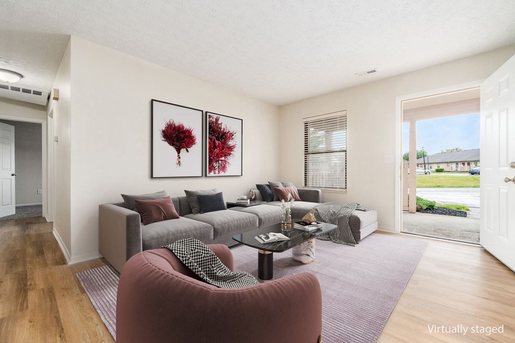 A living room with a grey couch and a red armchair.