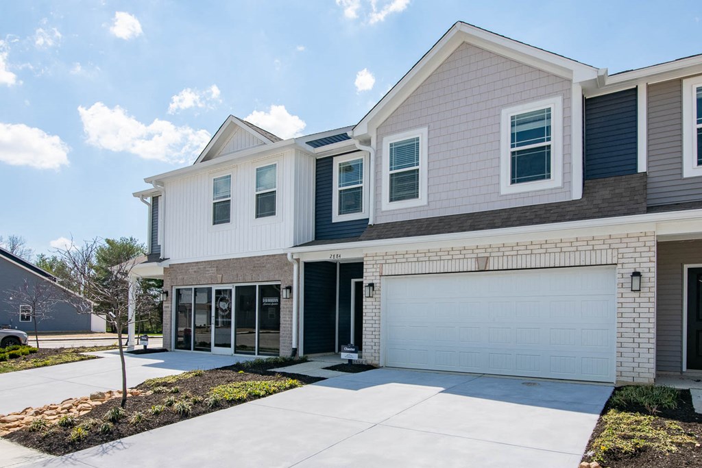 a house with a garage door and a driveway at Jackson Run Townhomes, Whitestown, IN 46075