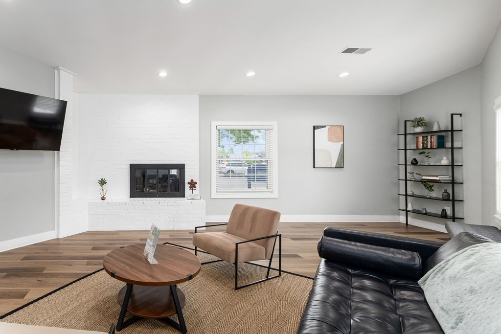 A living room with a fireplace, a chair, a coffee table, and a TV.