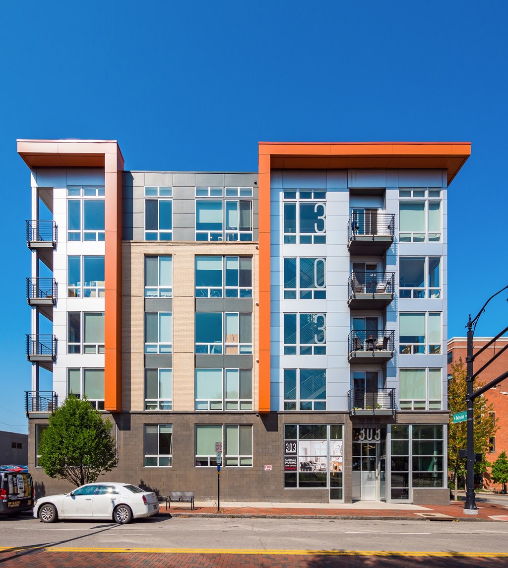 A modern building with a white car parked in front.