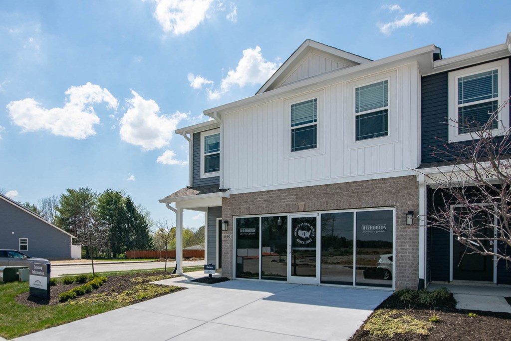 a white building with a sidewalk in front of it at Jackson Run Townhomes, Whitestown, IN 46075