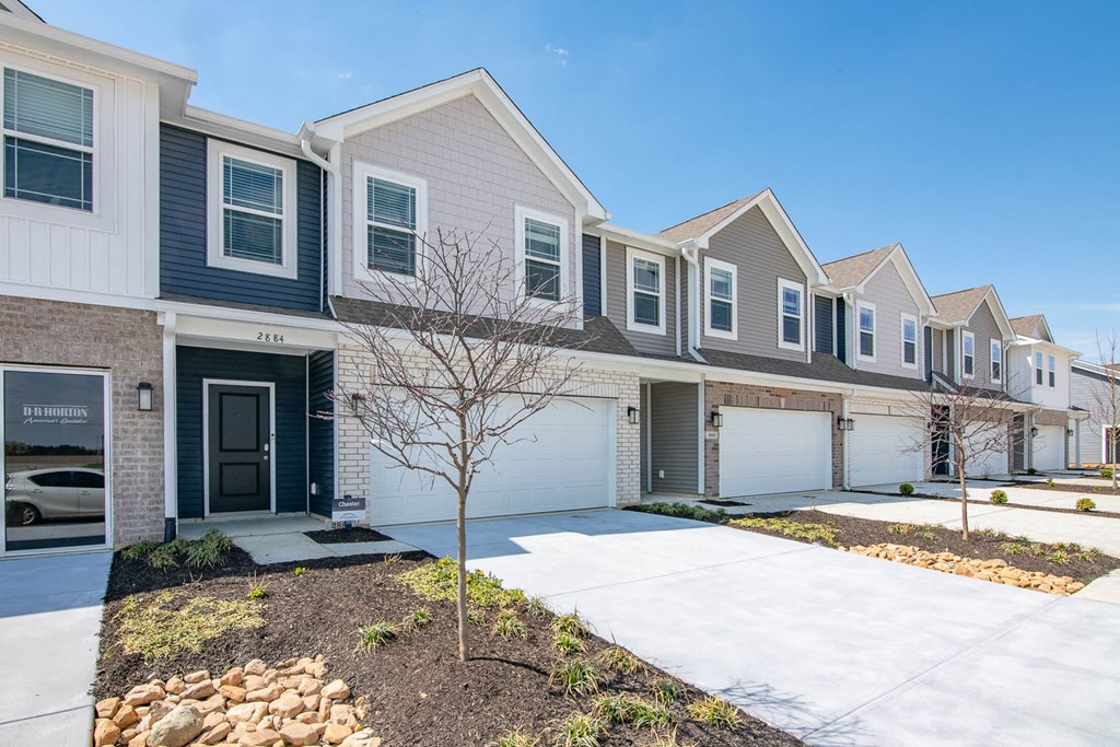 a row of houses with a snow covered sidewalk in front of them at Jackson Run Townhomes, Whitestown