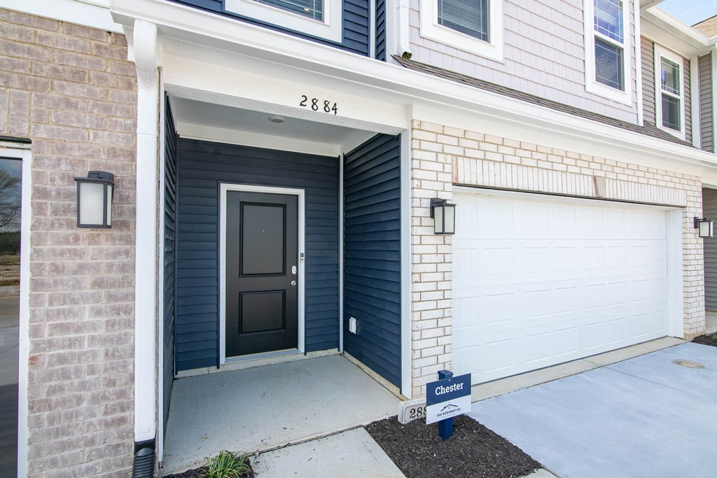 a front door of a house with two garage doors at Jackson Run Townhomes, Whitestown Indiana