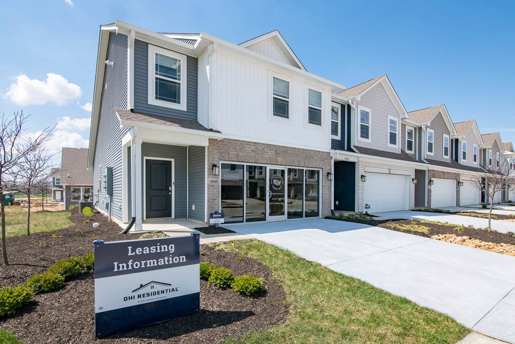 a building with a leasing information sign in front of it at Jackson Run Townhomes, Whitestown, 46075
