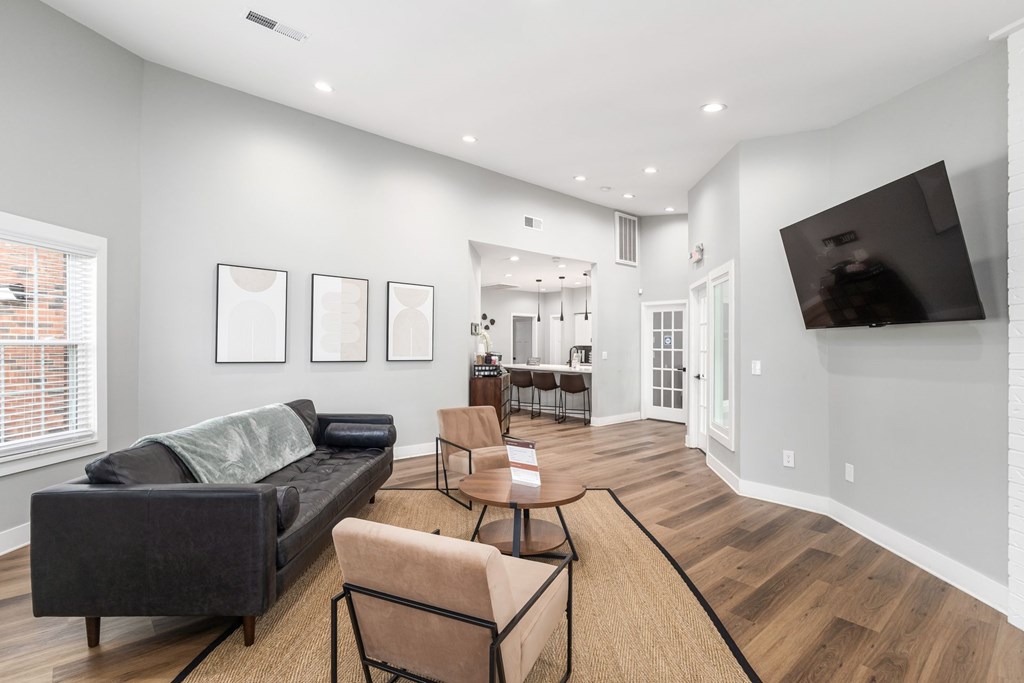 A living room with a grey couch and a wooden floor.