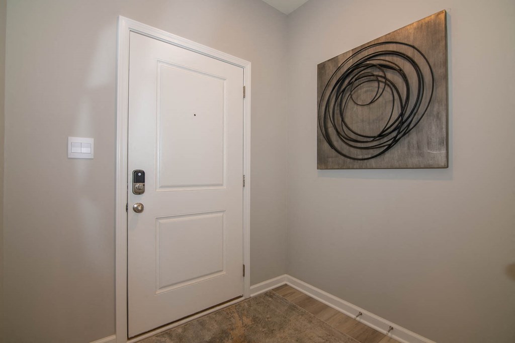 a bedroom with a white door and a painting on the wall at Jackson Run Townhomes, Whitestown, IN