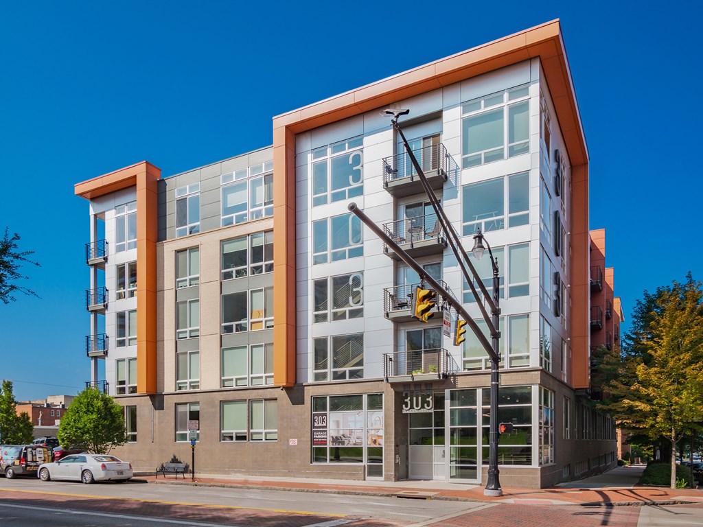 A modern building with a glass facade and a street in front of it.