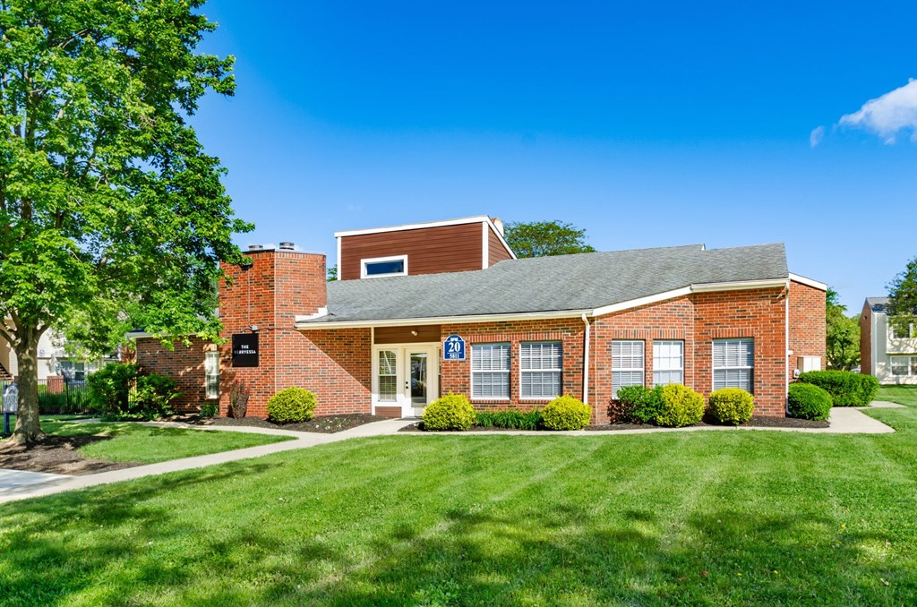 A small red brick building with a black sign on the front.