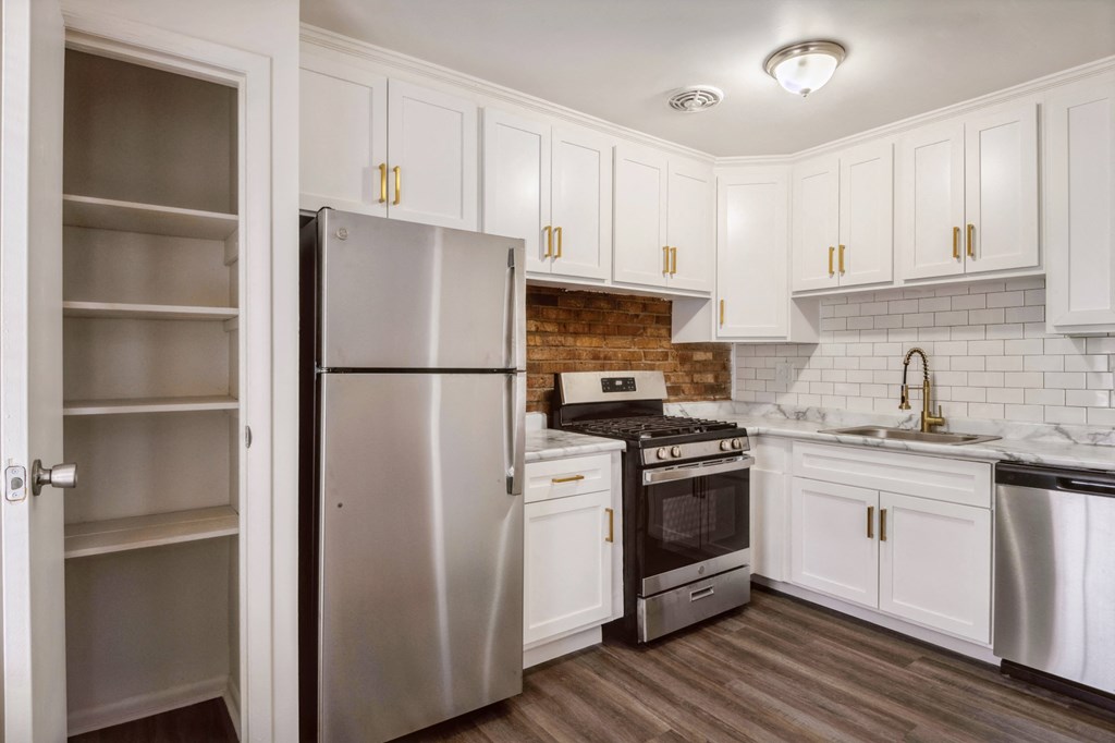 a kitchen with white cabinets and stainless steel appliances