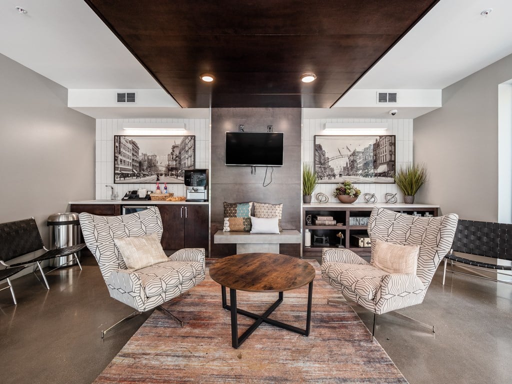 A living room with a wooden coffee table and two chairs.
