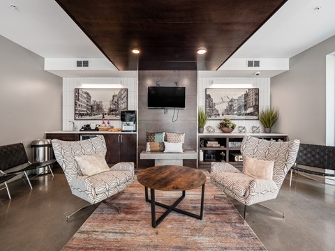 A living room with a wooden coffee table and two chairs.