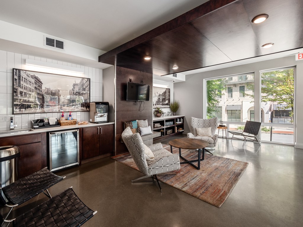 A modern living room with a kitchen area in the background.