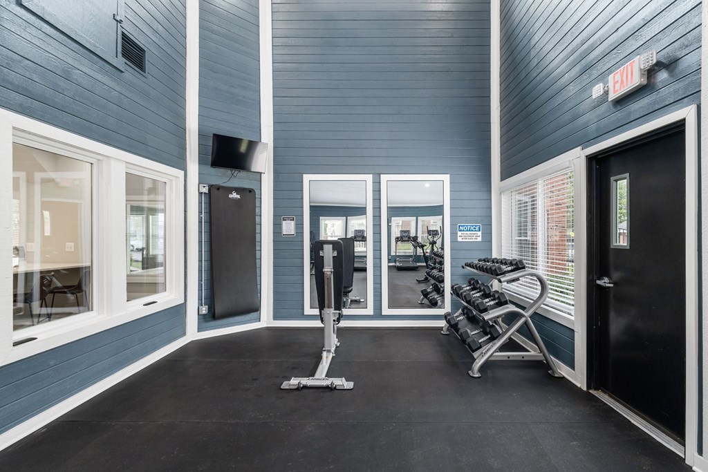 A gym with a blue wall and a treadmill.