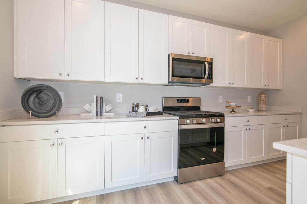 a kitchen with white cabinets and a stove top oven at Jackson Run Townhomes, Indiana