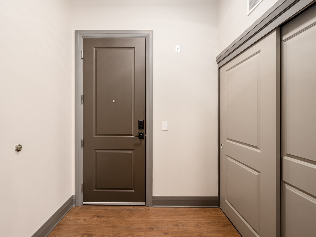 A brown door is in a white room.