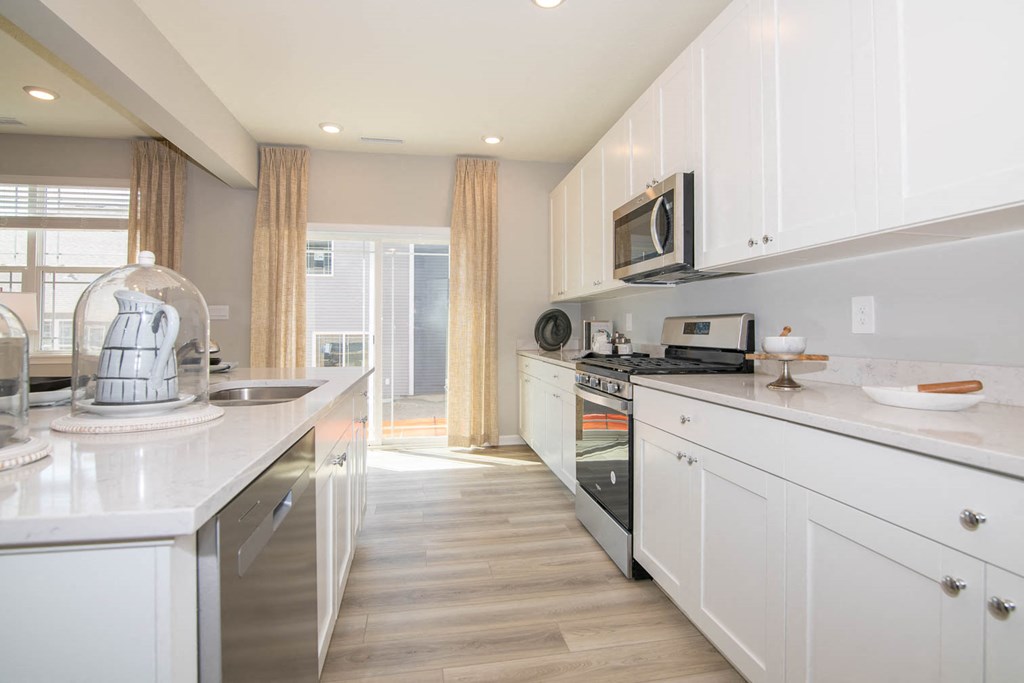a kitchen with white cabinets and a counter top at Jackson Run Townhomes, Indiana