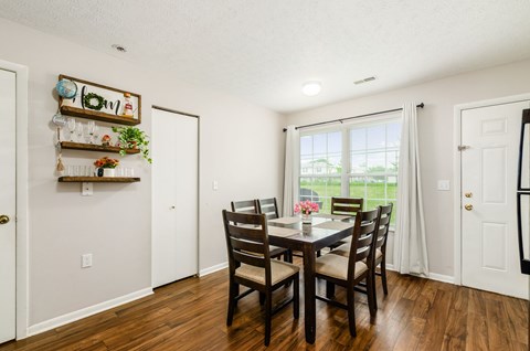 A dining room with a wooden table and chairs.