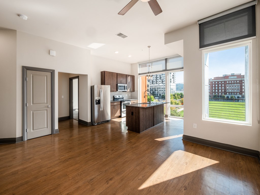 A modern kitchen with a refrigerator, sink, and a window overlooking a cityscape.