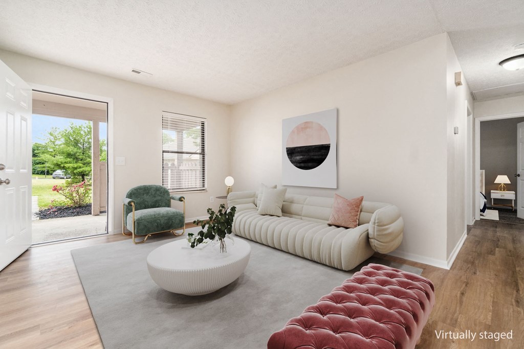 A living room with a white couch and a green chair.