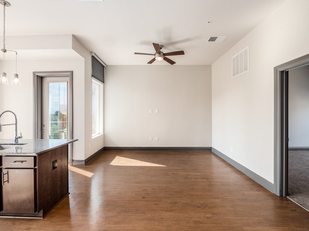 A kitchen with a wooden floor and a ceiling fan.