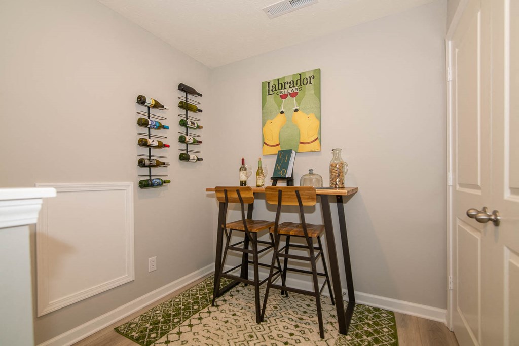 a bar with three stools in a room with a door and a wall with at Jackson Run Townhomes, Indiana