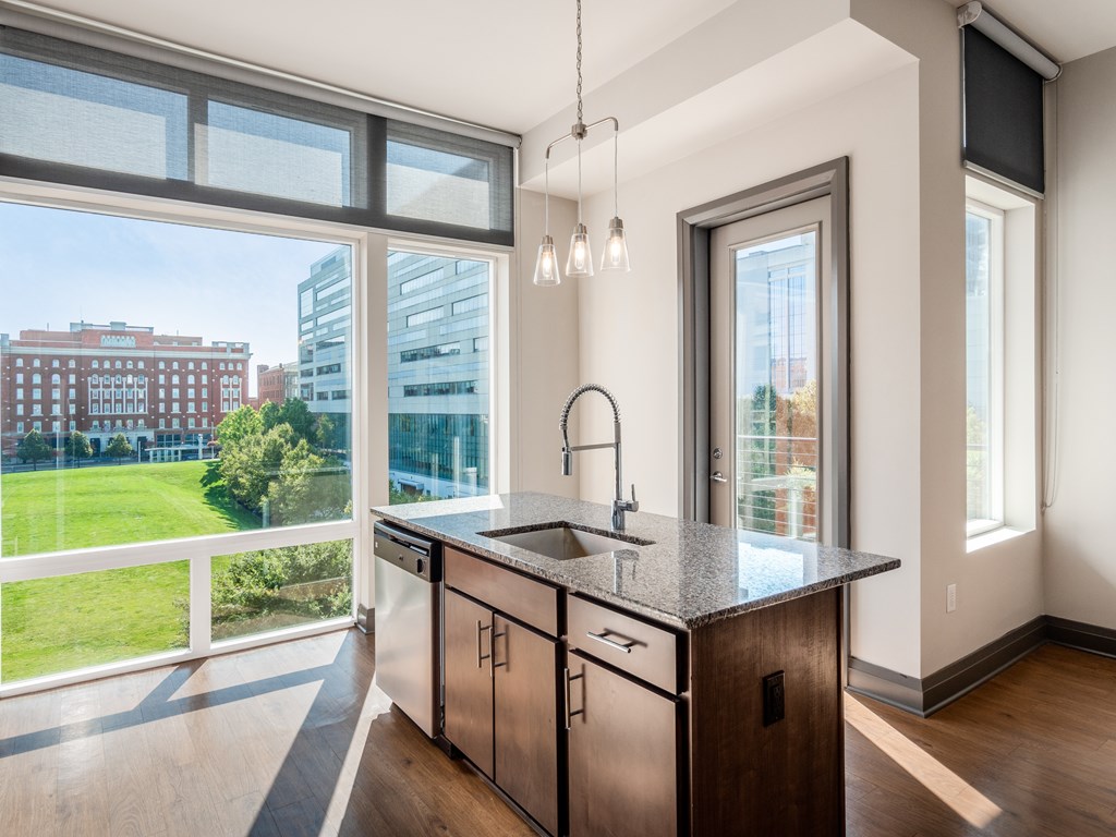 A kitchen with a large window overlooking a cityscape.