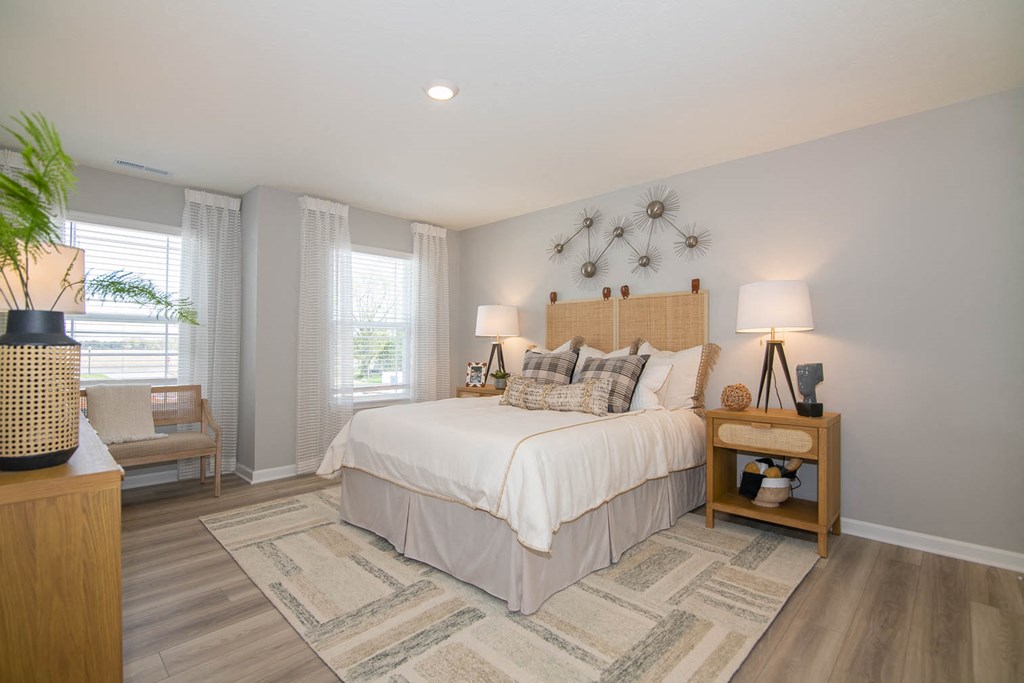 a bedroom with a bed and two windows at Jackson Run Townhomes, Whitestown, IN